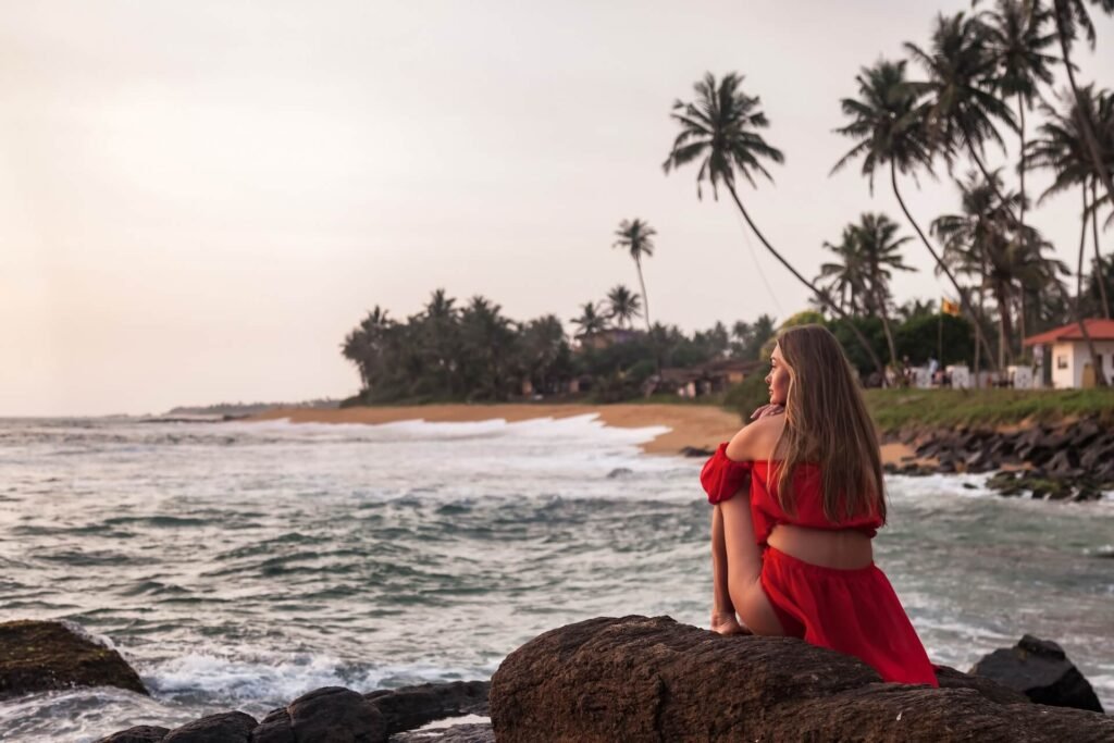 pretty-young-lady-in-red-dress-sitting-on-rock-at-2026-01-08-23-02-55-utc