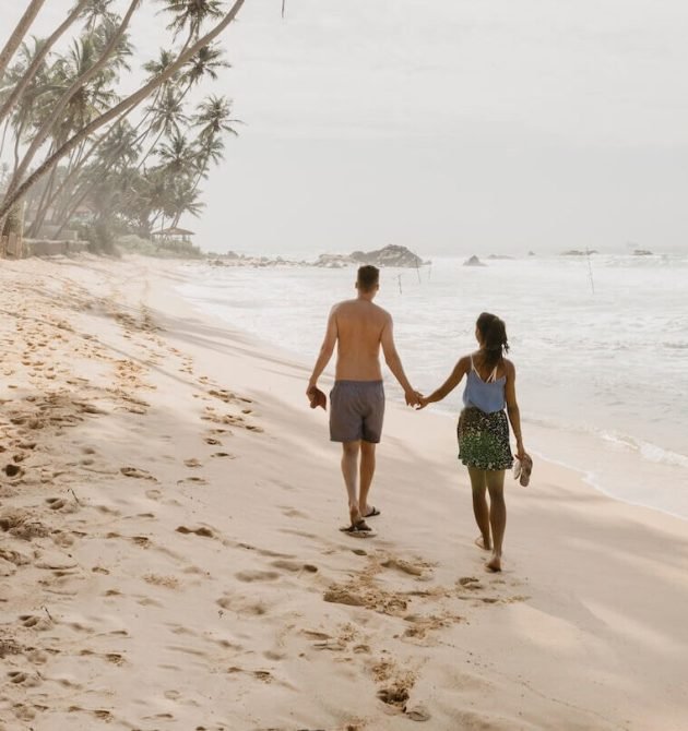 full-length-of-couple-walking-on-beach-against-sky-2026-01-05-00-41-09-utc