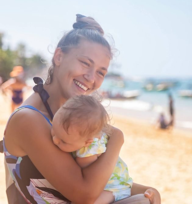 smiling-happy-mom-with-baby-in-arms-at-tropical-sa-2026-01-08-23-22-35-utc